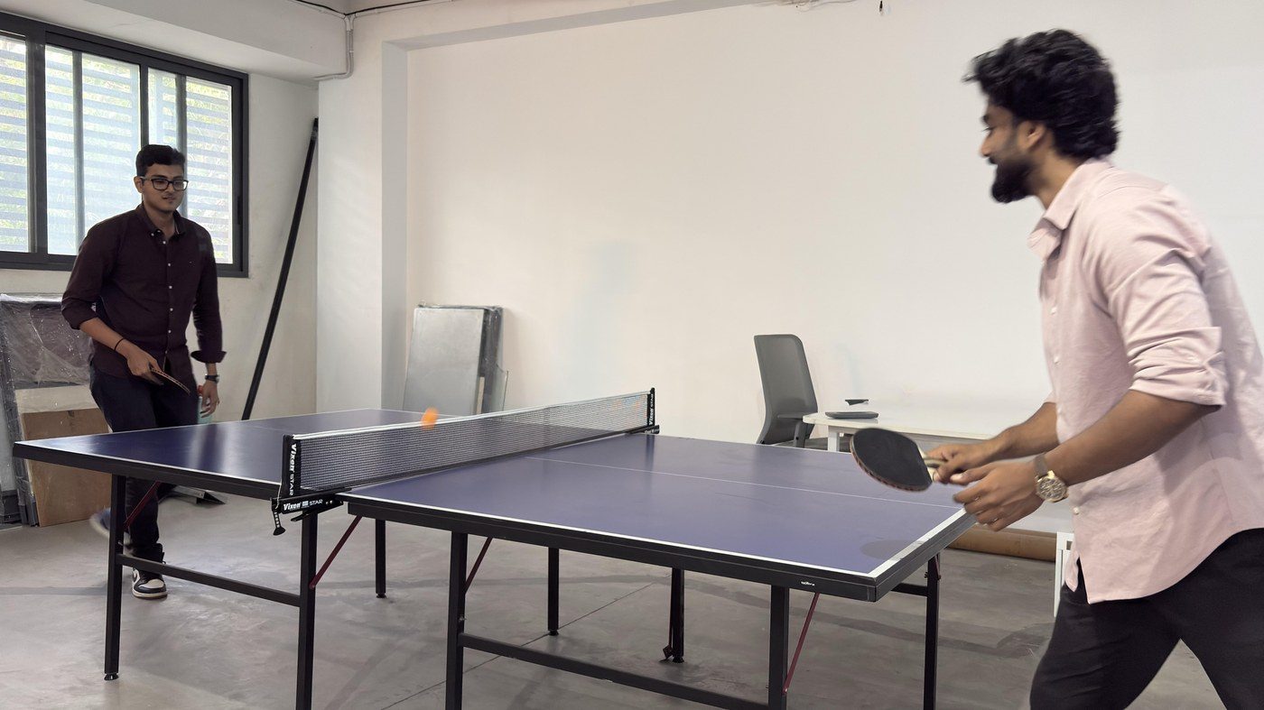 Colleagues playing table tennis at the office