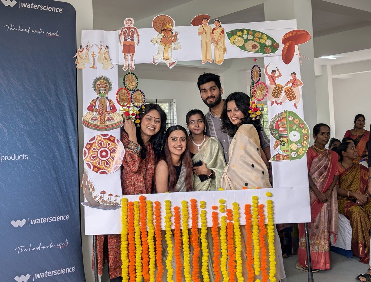 Colleagues celebrating Onam with a decorated photo frame